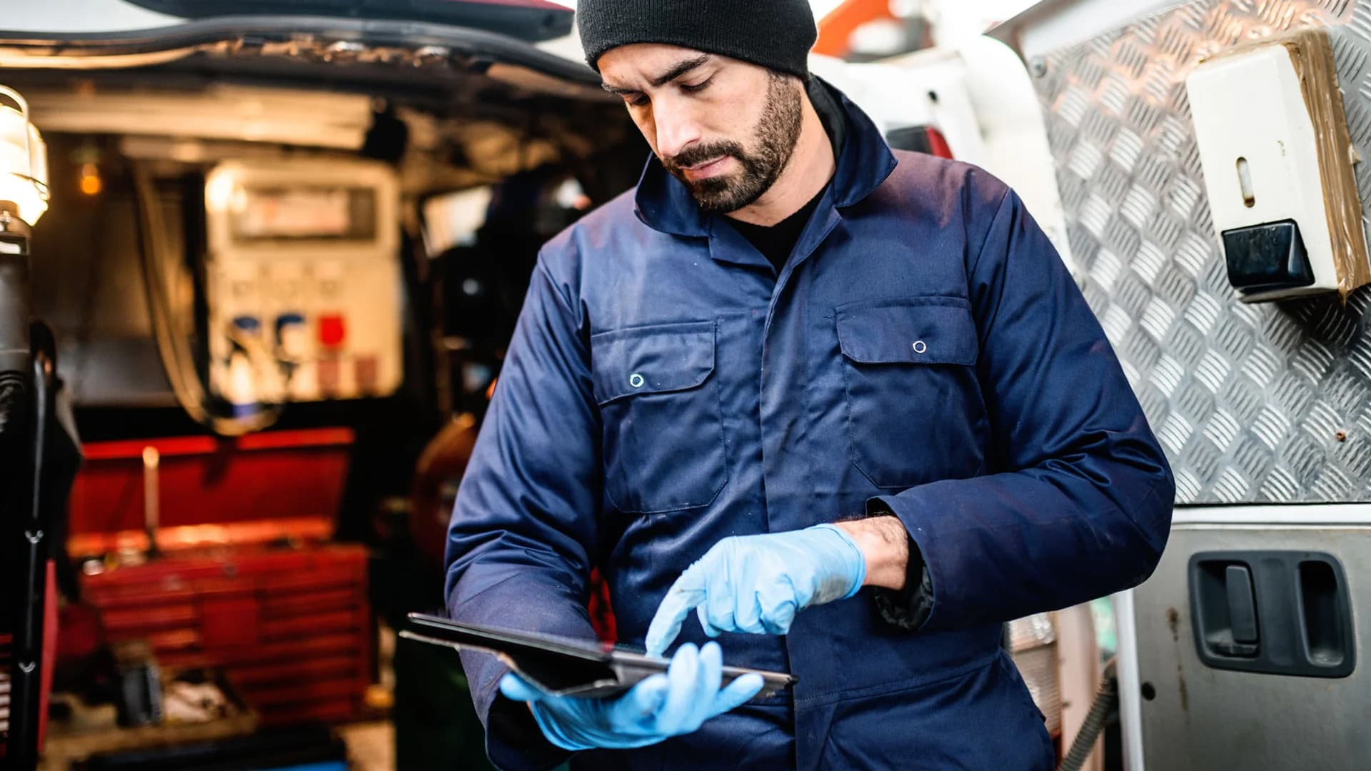 Roofing contractor checking job details on a tablet