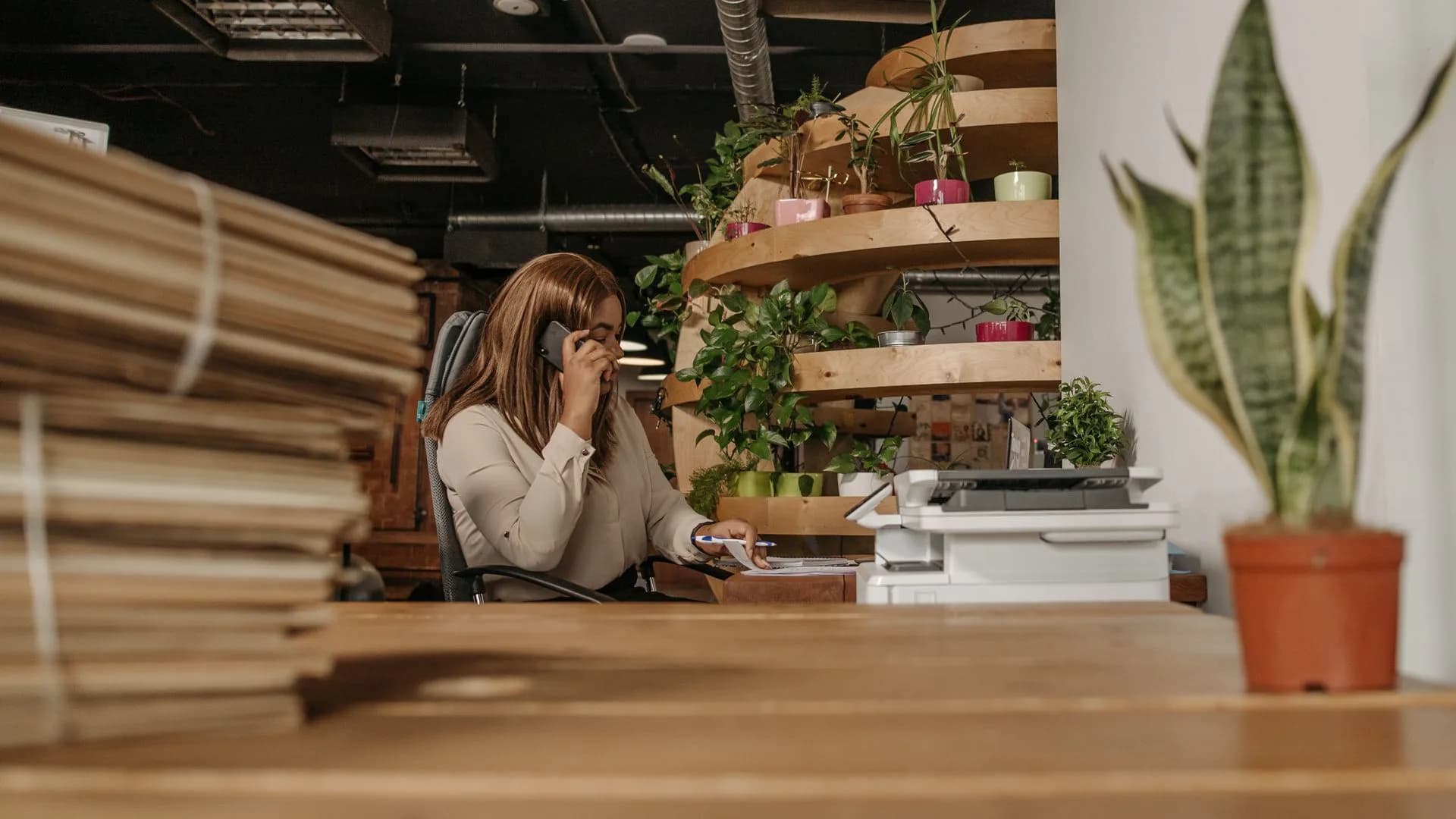 Professional taking a phone call at a busy office desk